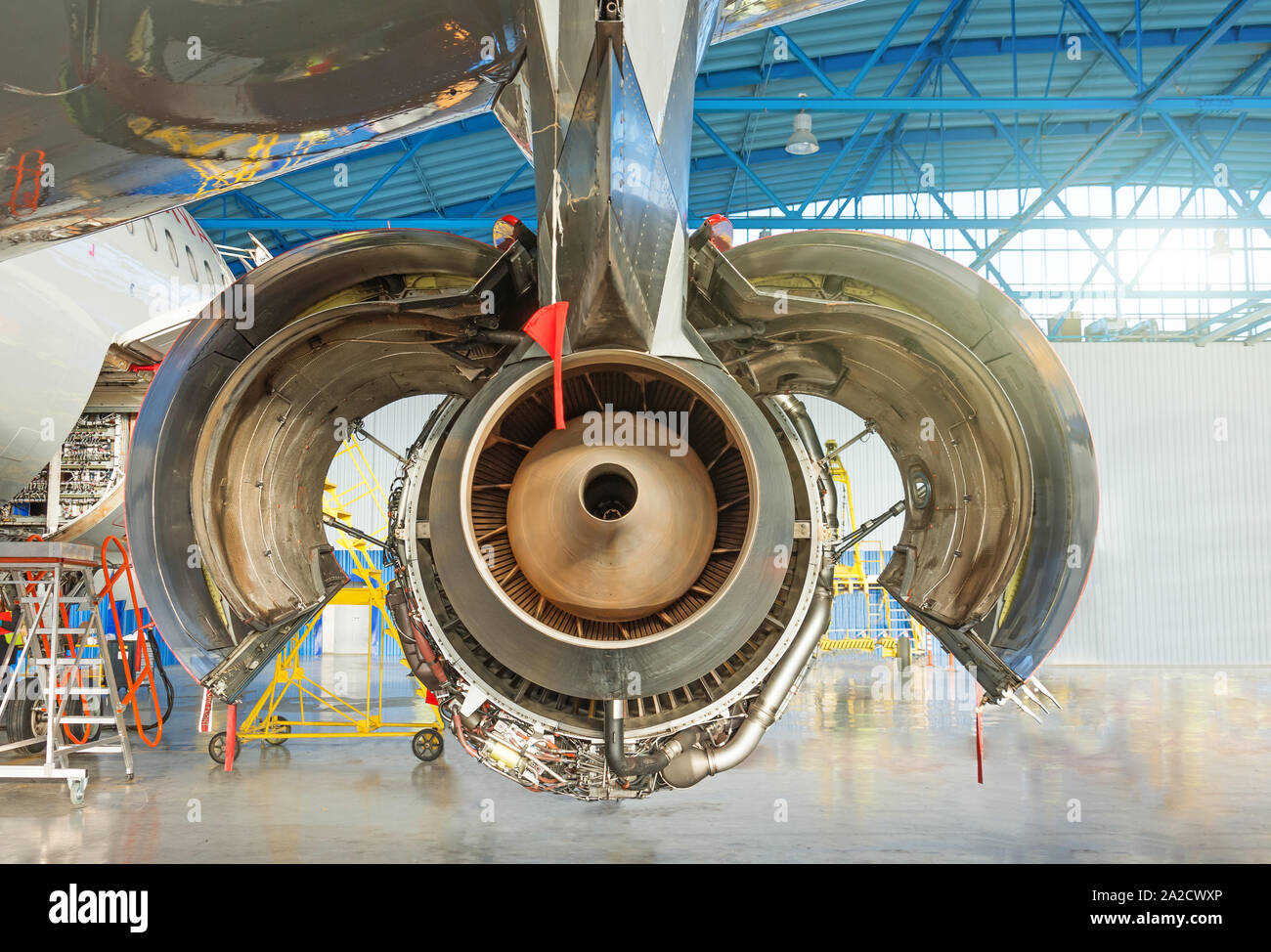 Piani del motore con cappa aperta lembi sul mantenimento in un hangar. Vista posteriore, ugello Foto Stock