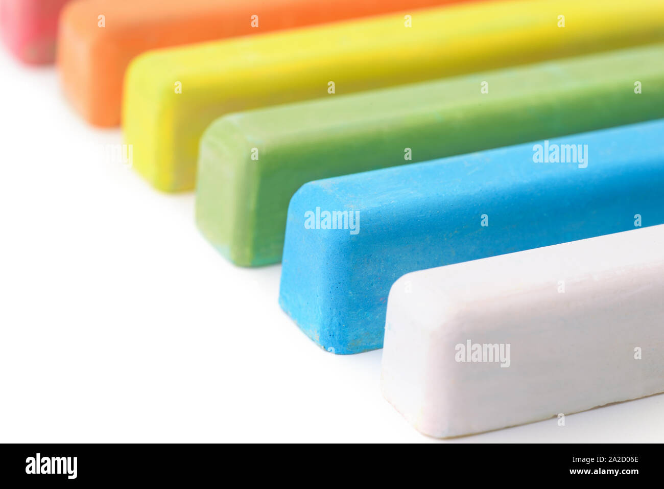Close up di gesso colorato aderisce su sfondo bianco Foto Stock