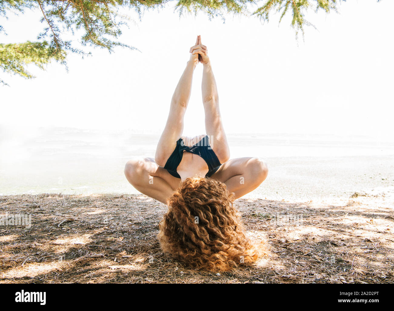 Donna fare yoga sulla riva del mare, Bainbridge Island, nello Stato di Washington, USA Foto Stock