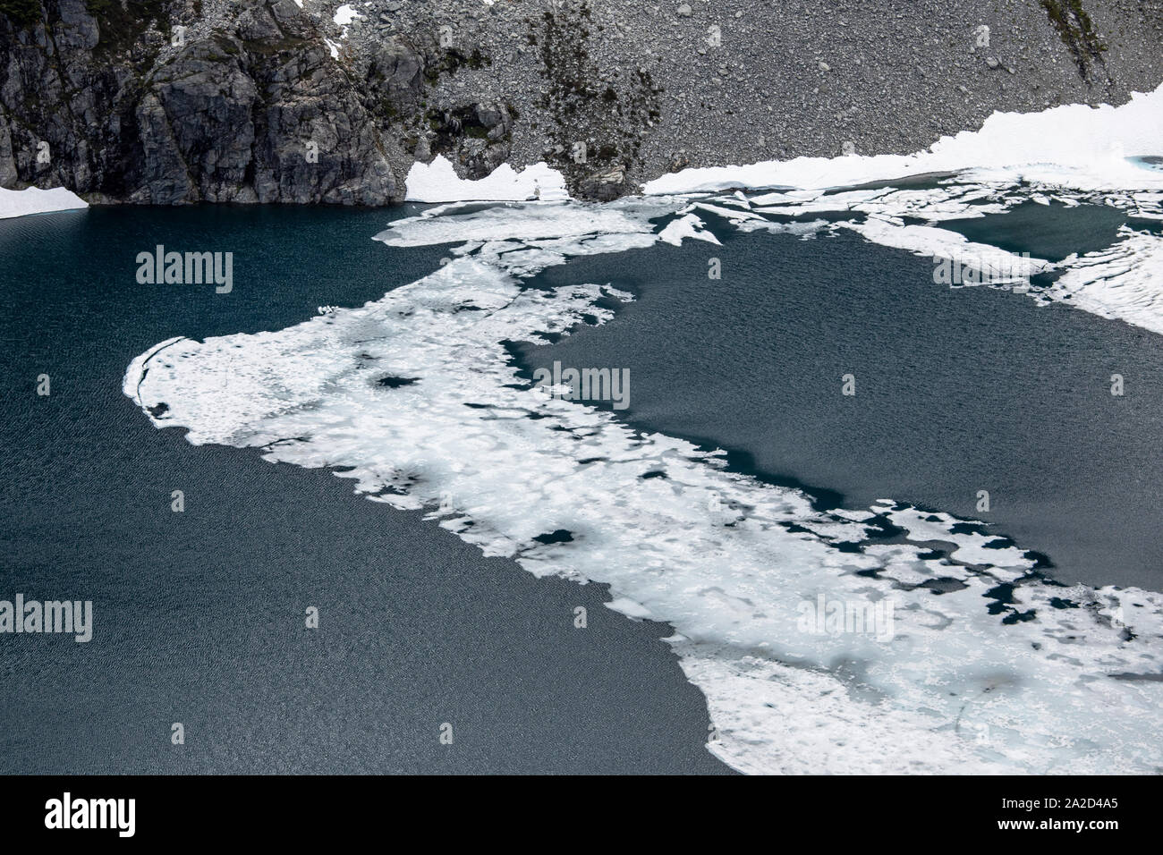 L'ultimo bit di ghiaccio si scioglie fuori un lago alpino d'estate. Foto Stock