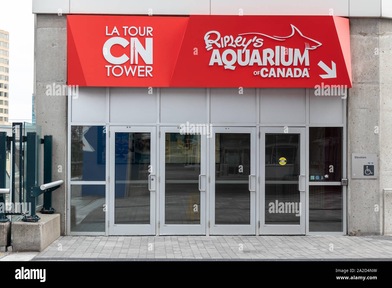 CN Tower e Ripley's Aquarium of Canada, segno sopra un ingresso giù per la plaza delle attrazioni popolari. Foto Stock
