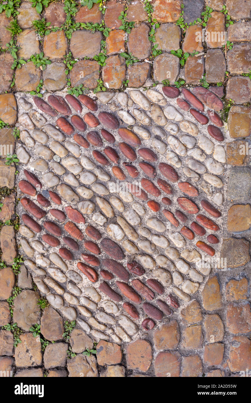 Scudo a forma di piccole pietre mosaico nella pavimentazione Foto Stock