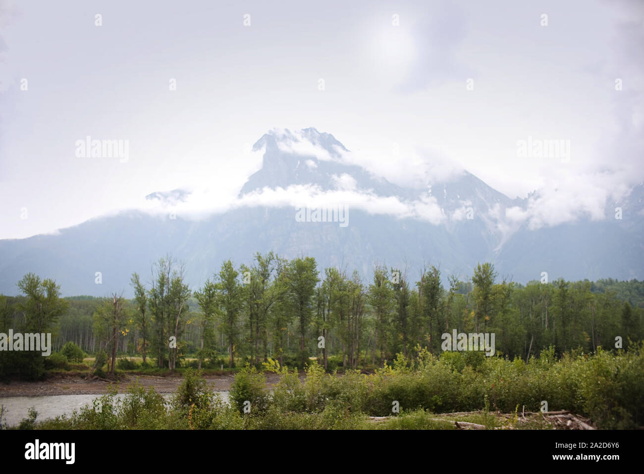 Serpeggiante fiume di fronte a una gamma di montagna. Foto Stock