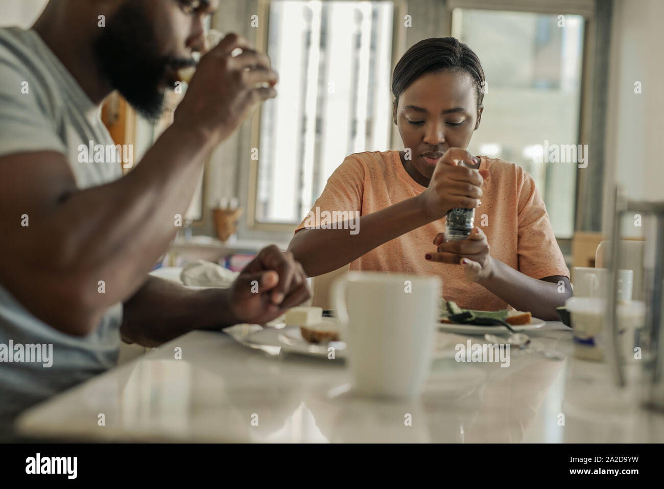 Giovane americano africano giovane seduto a casa avendo prima colazione Foto Stock
