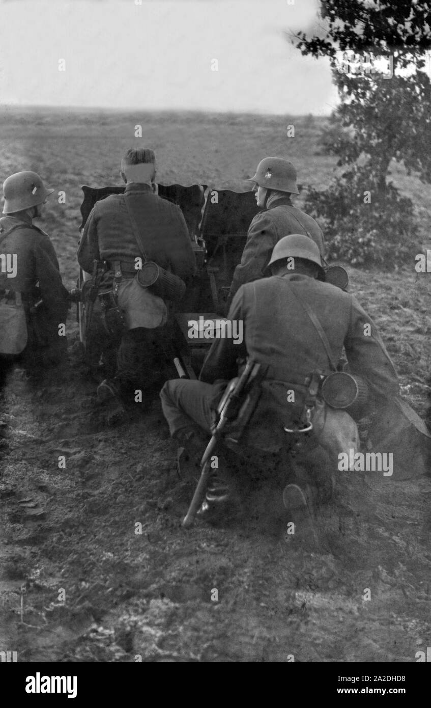 Soldaten des Infanterieregiments 9 üben auf einem Truppenübungsplatz mit dem 7,5 cm Infanteriegeschütz leichten 18, Deutschland 1930er Jahre. I soldati di fanteria su un addestramento militare esercizio di massa con un supporto di fanteria pistola, Germania 1930s. Foto Stock