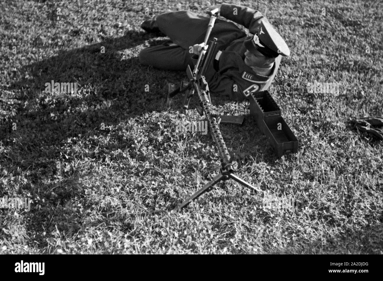 Der Ausbilder Feldwebel erläutert das Vorgehen bei einem Laufwechsel am Maschinengewehr MG 34, Deutschland 1930er Jahre. Il trapano sergente spiegare il cambiamento di una canna della pistola sulla mitragliatrice MG 34, Germania 1930s. Foto Stock