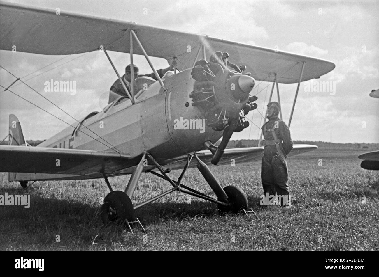 Zwei Soldaten am Ausbildungsflugzeug Bücker Bü 131 der Flieger Ausbildungsstelle Schönwalde, Deutschland 1930er Jahre. Due soldati al piano di formazione di Flieger Ausbildungsstelle Schoenwalde, Germania 1930s. Foto Stock