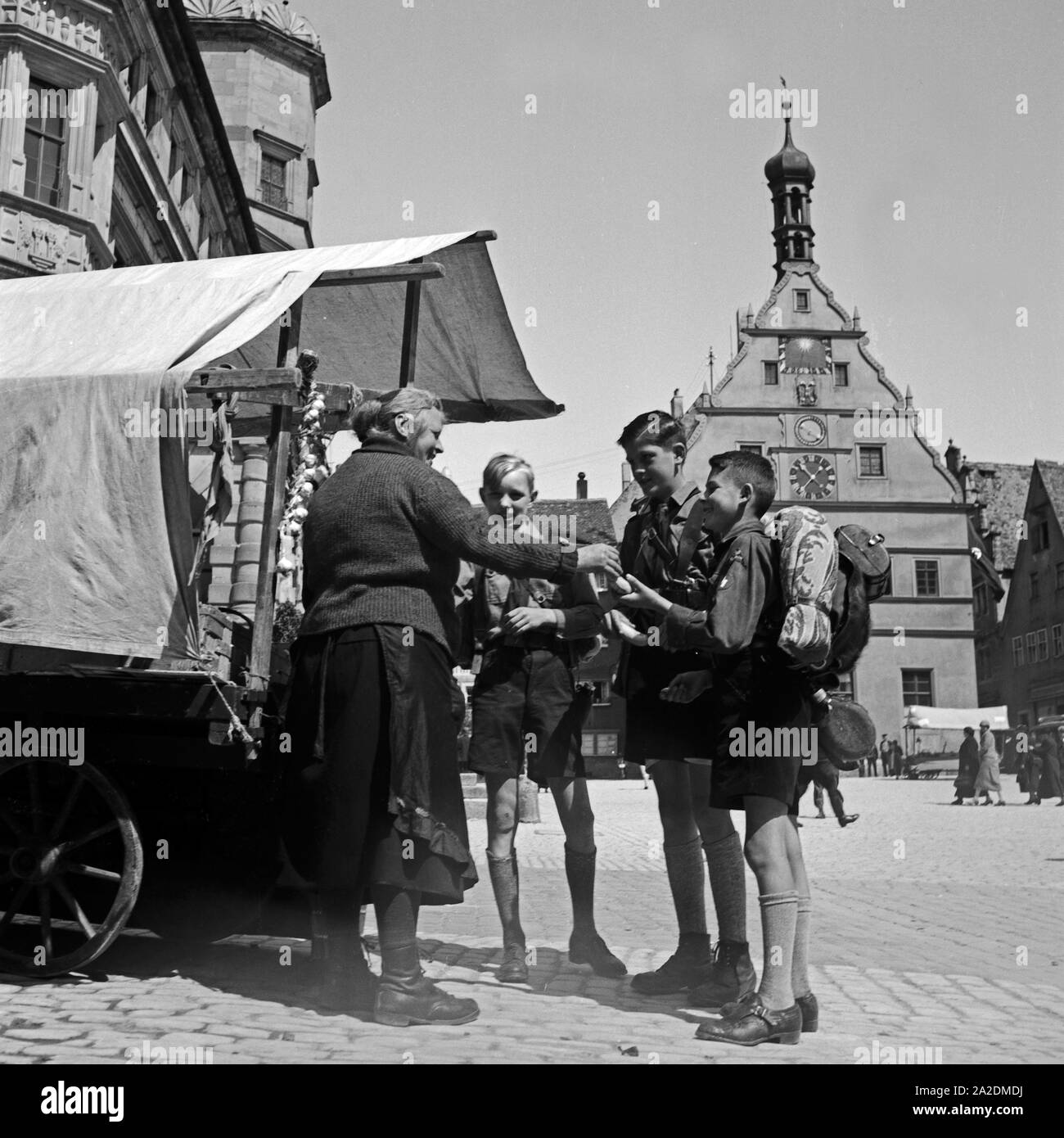 Eine Marktfrau schenkt drei Hitlerjungen Obst von ihrem Stand auf dem Markt di Rothenburg ob der Tauber, Deutschland 1930er Jahre. Tre giovani di Hitler sono riportati alcuni frutti da un mercato donna a Rothenburg ob der Tauber, Germania 1930s. Foto Stock