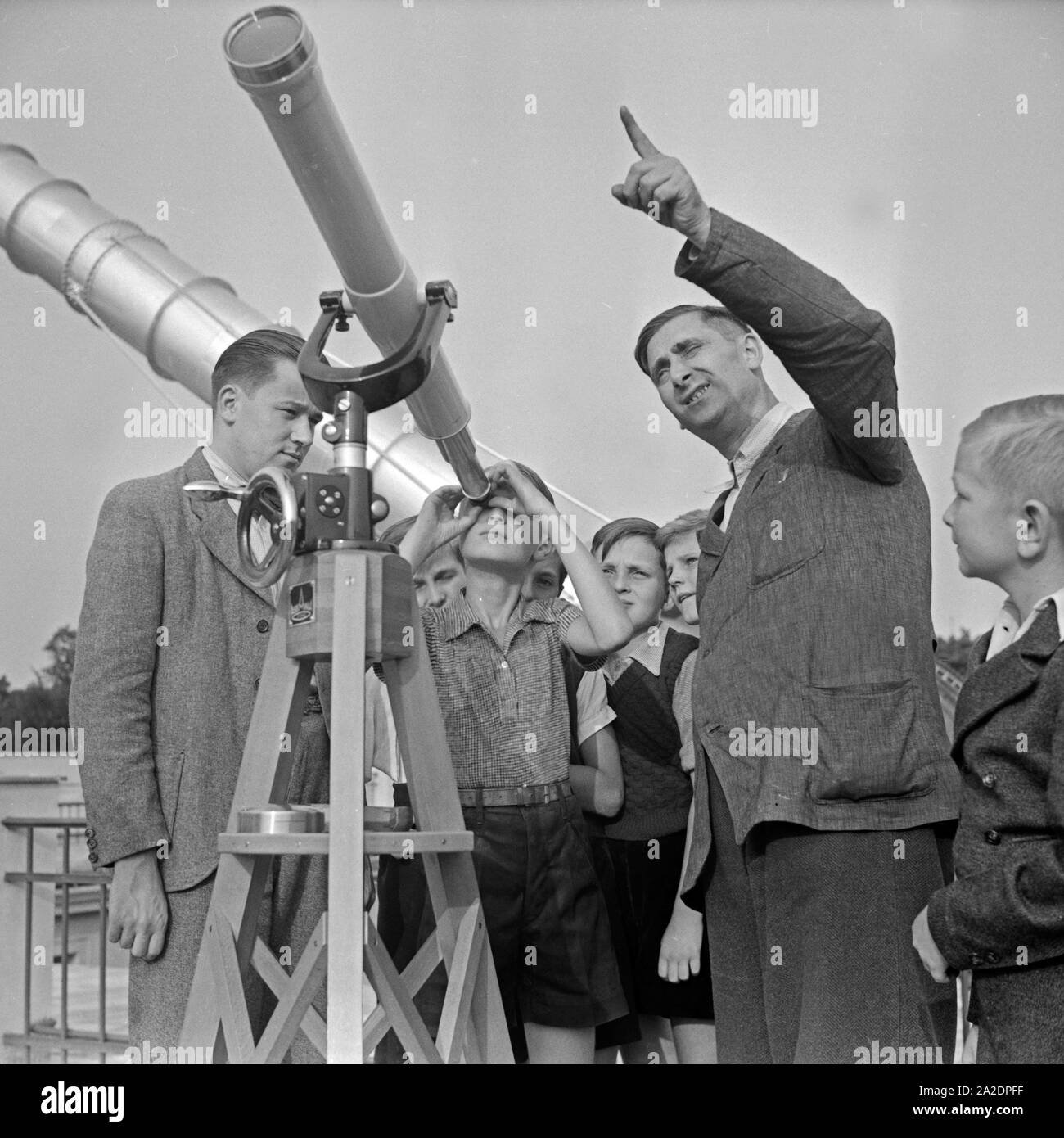 Ein Mitarbeiter erläutert die Funktionsweise eines Teleskops in der Sternwarte Berlin Treptow, Deutschland 1930er Jahre. Un membro del personale per spiegare la funzione di un telescopio a Berlino Treptow, osservatorio Germania 1930s. Foto Stock