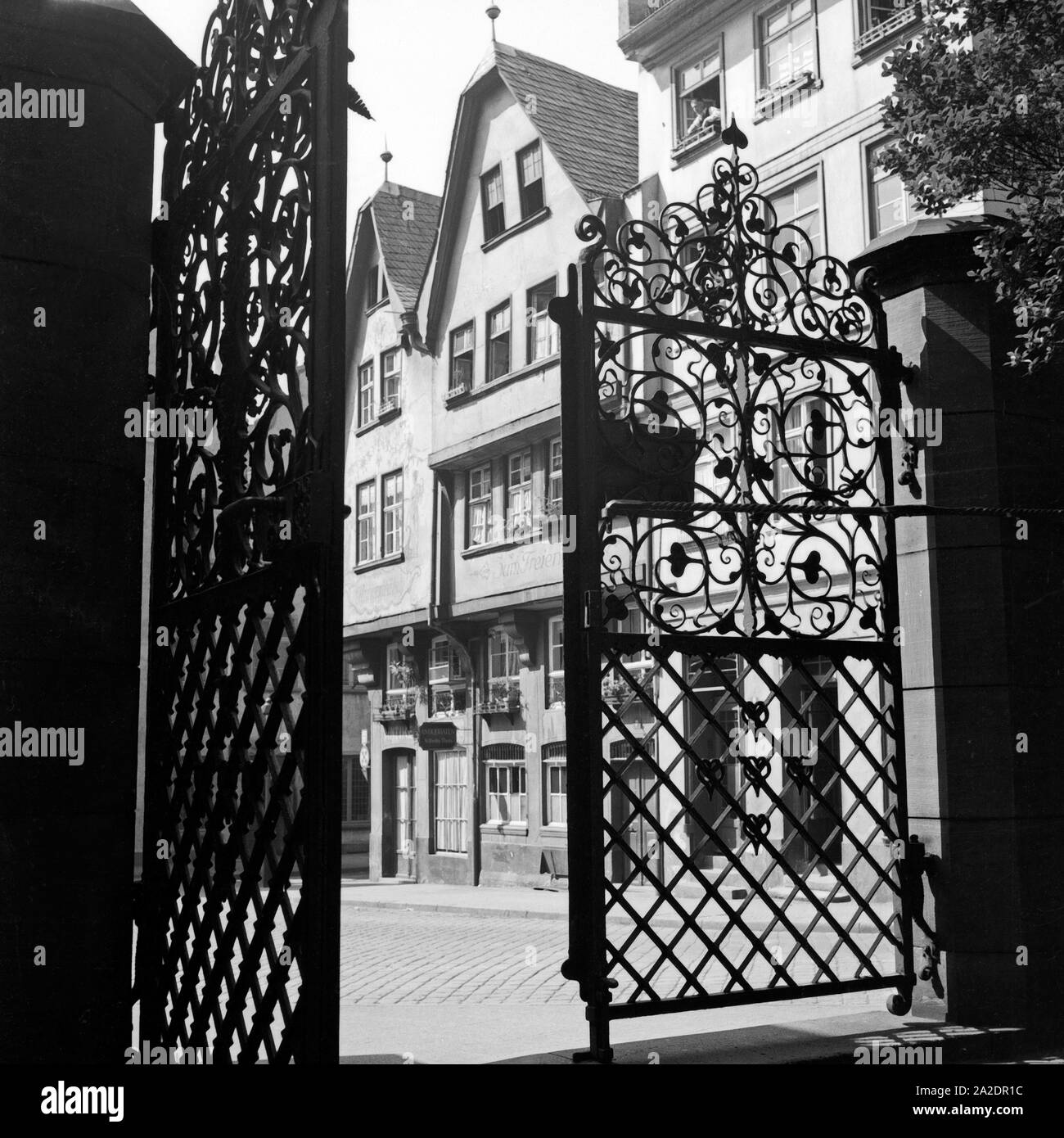Schweres schmiedeeisernes Tor mit Wirtshäusern in der Altstadt von Frankfurt am Main, Deutschland 1930er Jahre. Heavy cancellata in ferro battuto e ristoranti presso la città vecchia di Francoforte in Germania 1930s. Foto Stock