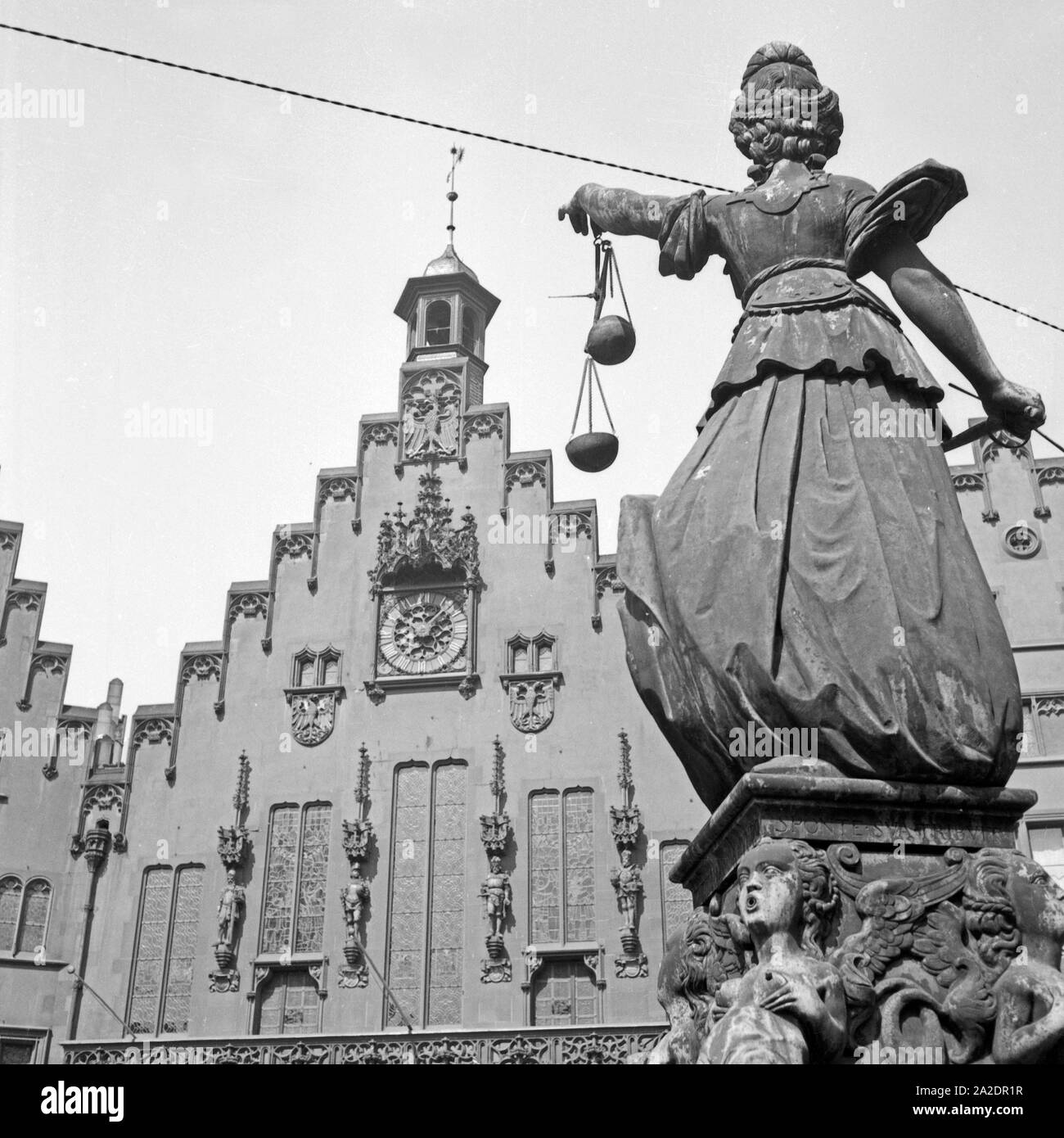Häuserzeile am Römerberg mit Justitia Skulptur in der Altstadt von Frankfurt am Main, Deutschland 1930er Jahre. Fila di case a Roemerberg nella città vecchia di Francoforte in Germania 1930s. Foto Stock