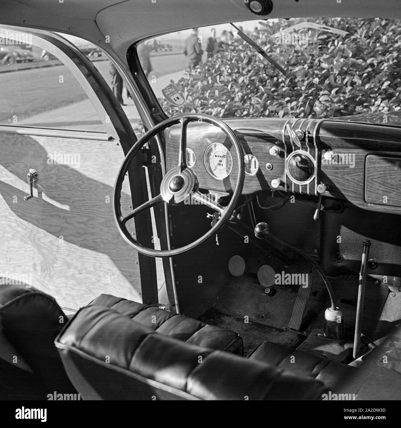 Fahrersitz eines Ford V8 Modell 68 mit Holzverkeidung vor der Firmenzentrale der Ford Werke in Köln Niehl, Deutschland 1930er Jahre. Sedile del conducente di una Ford V8 modello 68 con fogli di legno davanti al tedesco quartier generale di Ford a Colonia, Germania 1930s. Foto Stock