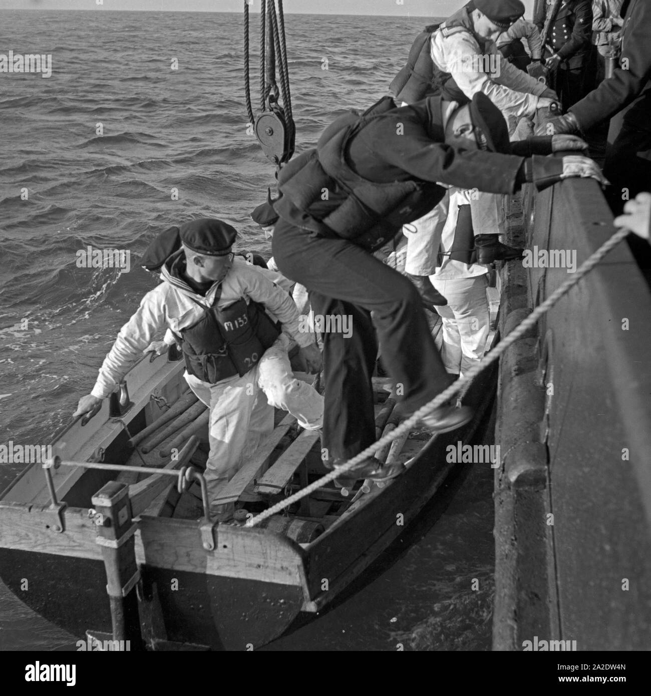 Marinerekruten der 2. Minensuchflottille beim Besteigen des Beibootes zum Seesportwettkampf Kutterpullen, Deutschland 1930er Jahre. Navy reclute della seconda flottiglia dragamine inserendo uno della nave di imbarcazioni di salvataggio per un concorso di canottaggio, Germania 1930s. Foto Stock