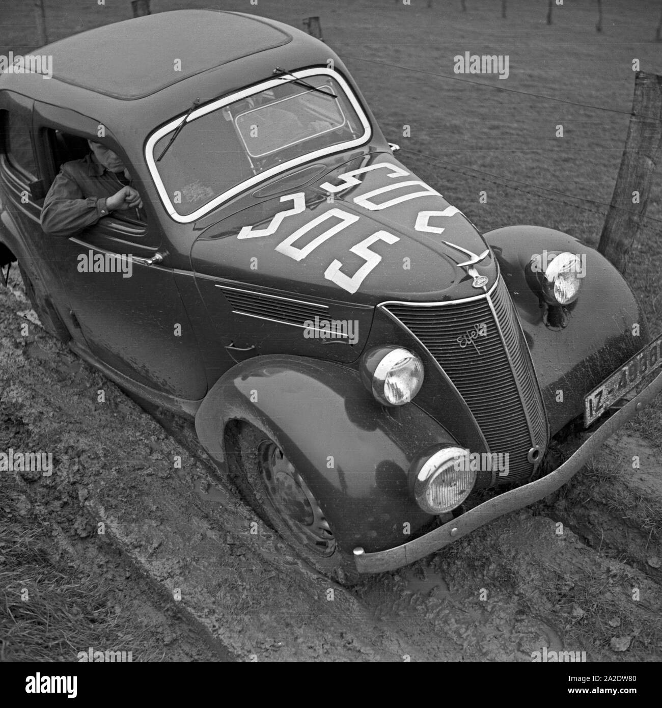 Ein Ford Eifel quält sich bei einer durch Autorallye ein Schlammloch, Deutschland 1930er Jahre. Un modello Ford Eifel lottando attraverso un foro di fango ad un auto rallye, Germania 1930s. Foto Stock