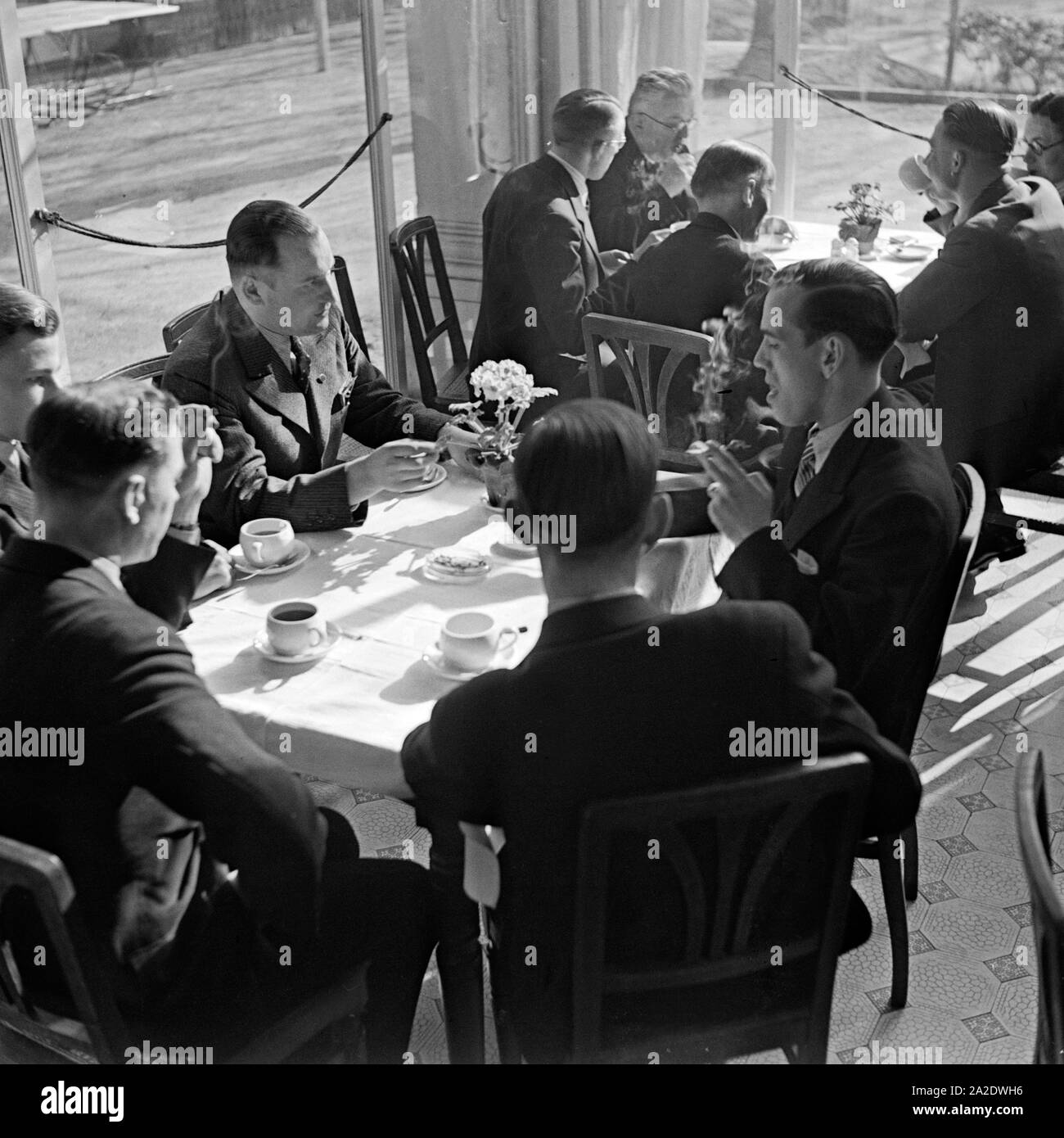 Eine Reisegruppe entspannt bei einer Tasse Kaffee vom Besichtigungsprogramm, Deutschland 1930er Jahre. Un gruppo di viaggiatori di rilassarsi con una tazza di caffè dal loro programma di escursione, Germania 1930s. Foto Stock
