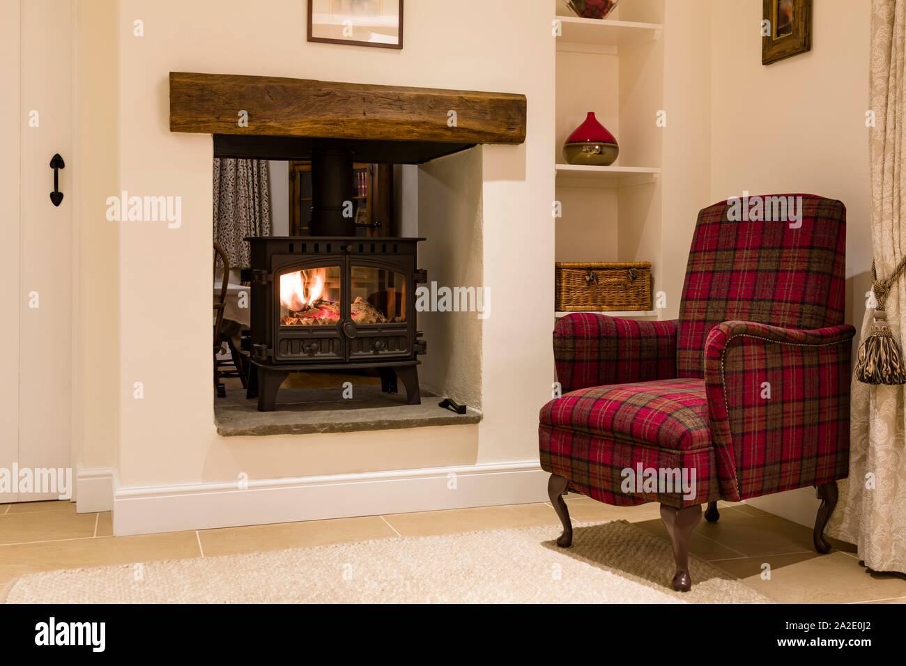 Accogliente e woodburner sedia in una casa inglese, REGNO UNITO Foto Stock
