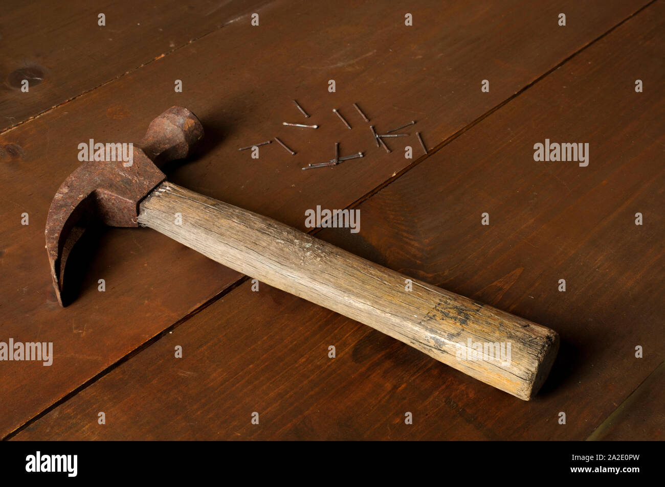 Fotografia di vita ferma, vecchio martello, e unghie su una tavola rustica di legno Foto Stock