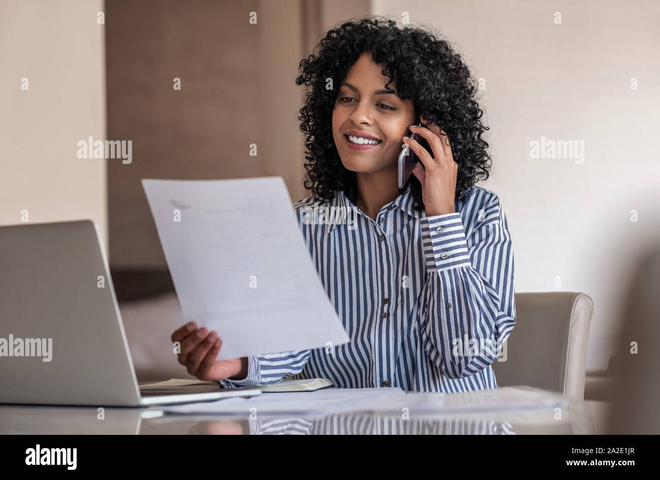 Donna sorridente imprenditore parlando sul suo cellulare e la lettura dei documenti Foto Stock