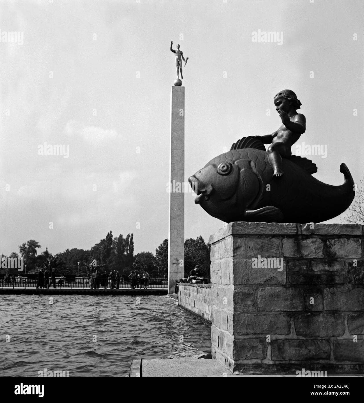 Die Fackelträgersäule und der Putto auf Fisch des Bildhauers Hermann Scheuernstuhl am Maschsee bei Hannover, Deutschland 1930er Jahre. Obelisco e putto su un pesce come sculture dell'artista Hermann Scheuernstuhl presso la riva del lago Maschsee vicino Hannover, Germania 1930s. Foto Stock