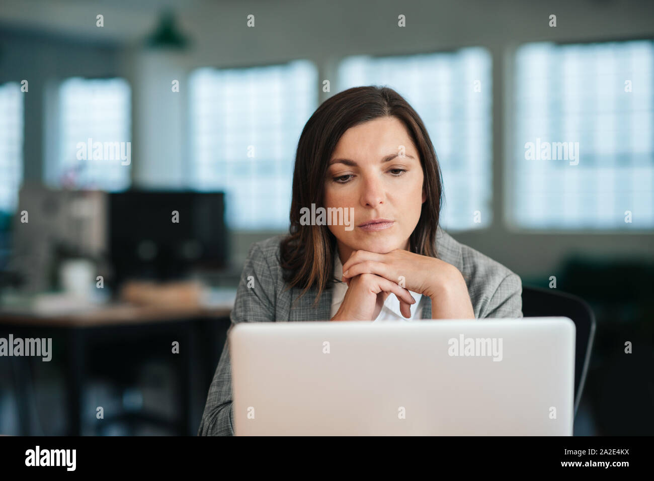 Focalizzato imprenditrice lavorando su un portatile nel suo ufficio Foto Stock
