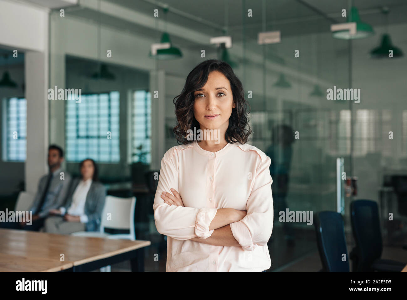 Giovane imprenditrice in piedi con fiducia in un grande ufficio moderno Foto Stock