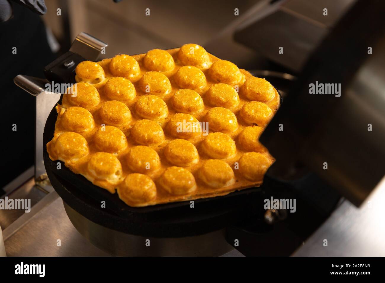 Rendendo cialde on dark waffle ferro, scatti Foto Stock