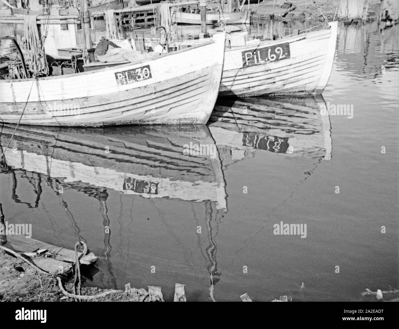 Fischkutter warten im Hafen auf die nächste Ausfahrt, Ostpreußen, 1930er Jahre. Pescherecci con reti da traino per pesce in attesa presso il porto per il prossimo progetto di pesce, Prussia orientale, 1930s. Foto Stock