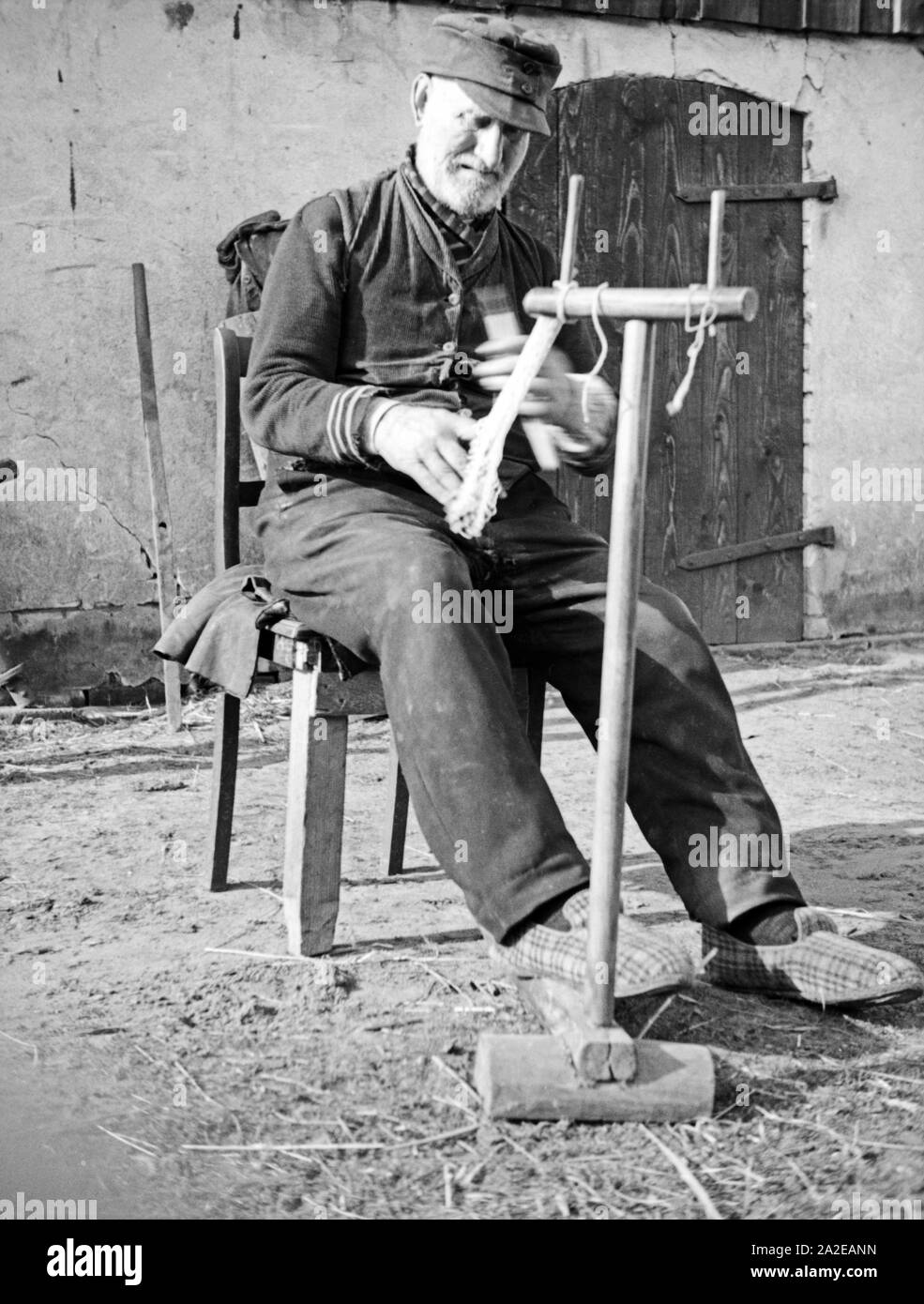 Ein alter Fischer repariert sein Netz in Ostpreußen, 1930er Jahre. Un vecchio pescatore riparando il suo netto, Prussia orientale, 1930s. Foto Stock