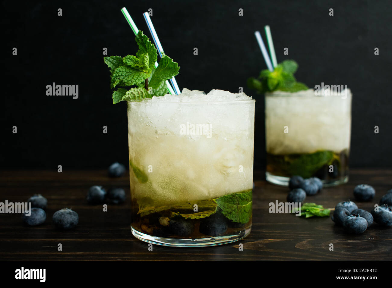 Mirtillo Mint Julep cocktail con decorazione: Due cocktail realizzato con il bourbon whiskey, mirtilli, e foglie di menta su ghiaccio tritato Foto Stock