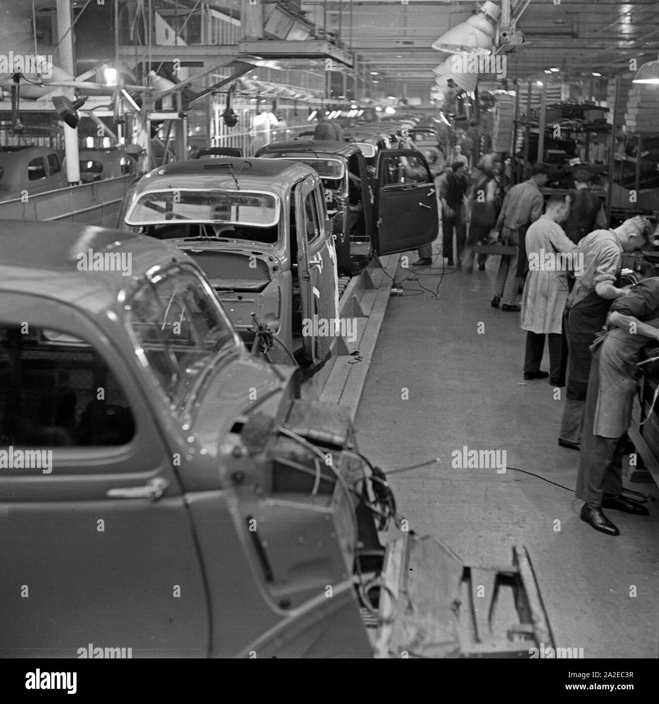 Karosserien schweben an den Arbeitern in den Ford Werken in Köln Niehl vorüber, Deutschland 1930er Jahre. Telaio venite a fianco dei lavoratori presso la fabbrica Ford a Colonia, Germania 1930s. Foto Stock