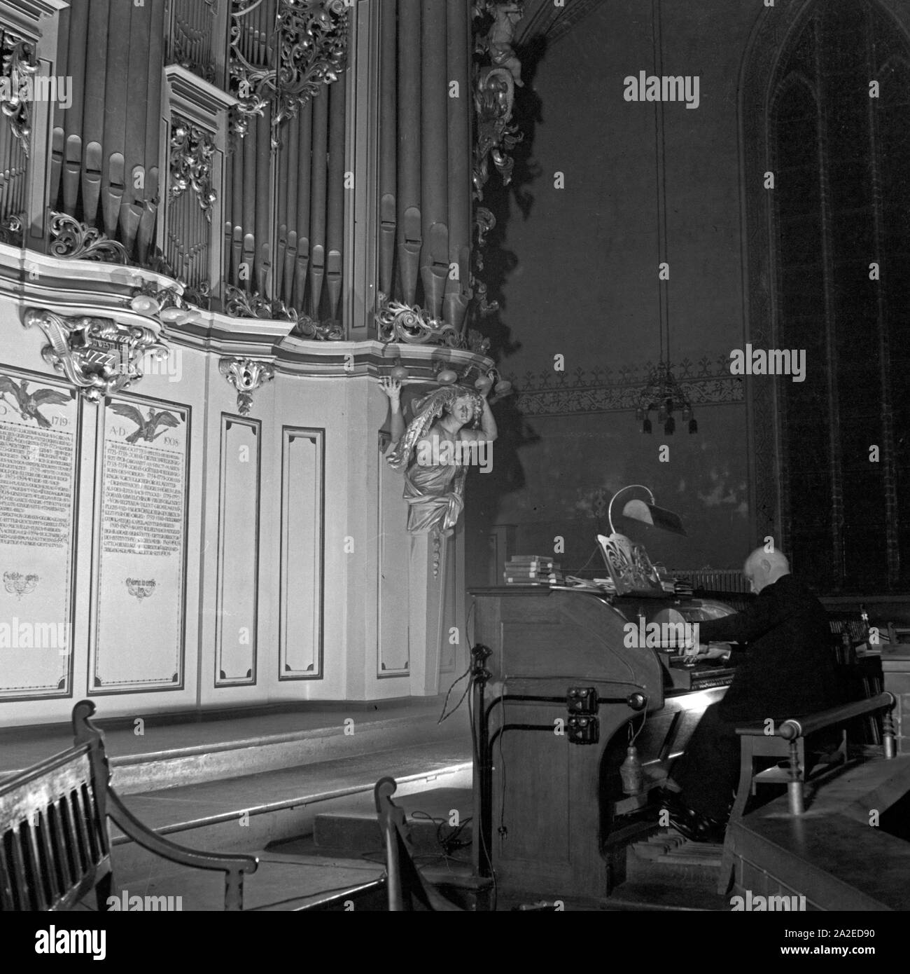 Ein Kantor spielt Orgel in einer Kirche in der Vorweihnachtszeit, Deutschland 1930er Jahre. Un uomo giocando l'organo presso una chiesa nella pre periodo natalizio, Germania 1930s. Foto Stock