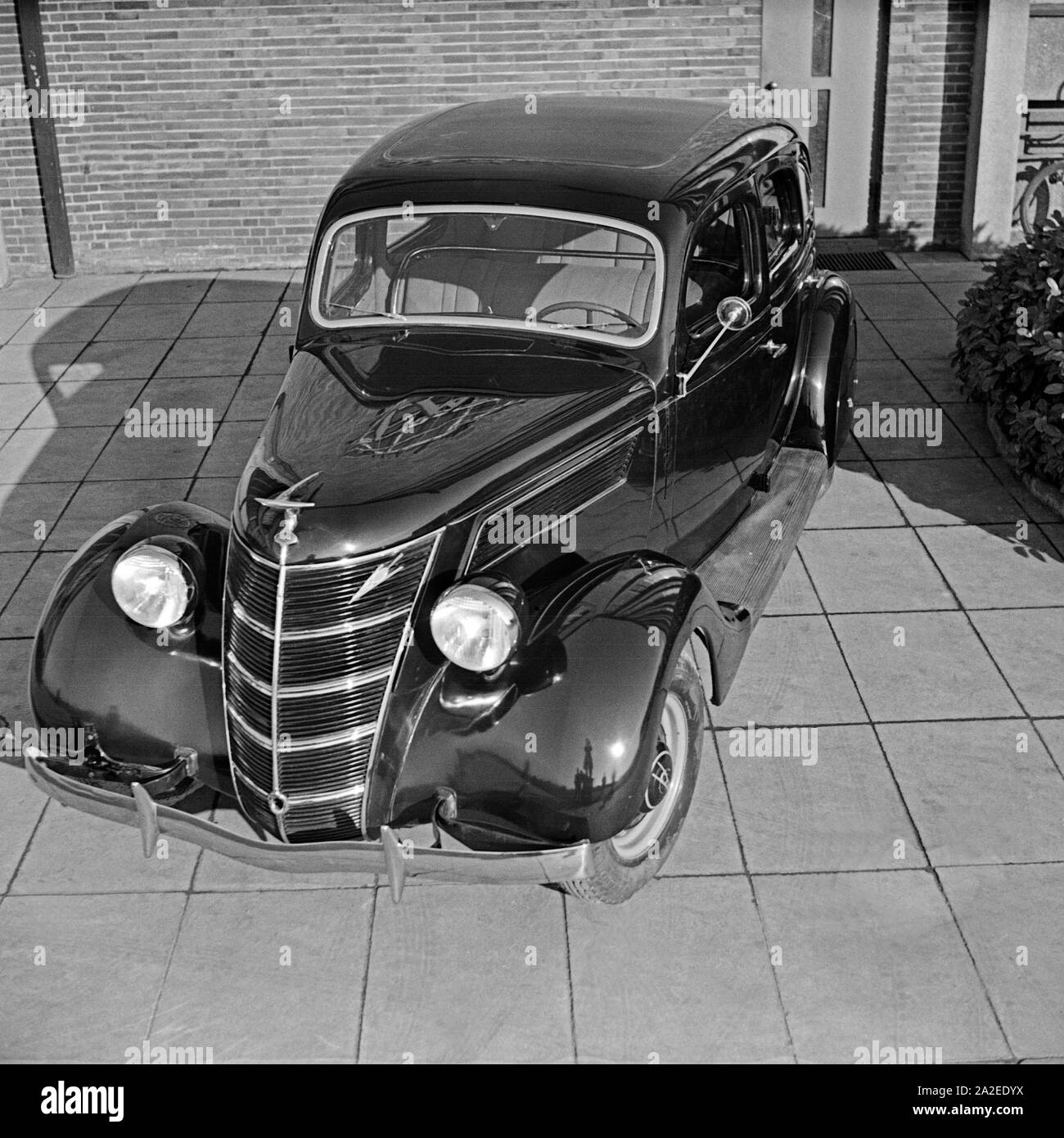 Ford V8 vor der Firmenzentrale der Ford Werke in Köln Niehl, Deutschland 1930er Jahre. Una Ford V8 nella parte anteriore del tedesco Ford sede a Colonia, Germania 1930s. Foto Stock