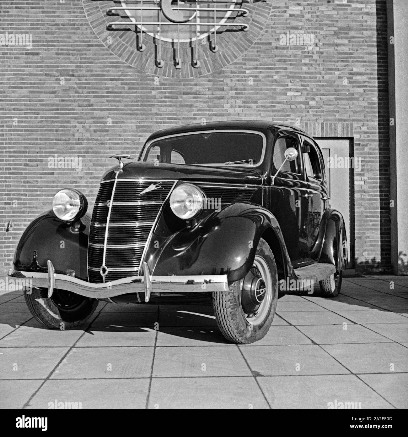 Ford V8 vor der Firmenzentrale der Ford Werke in Köln Niehl, Deutschland 1930er Jahre. Una Ford V8 nella parte anteriore del tedesco Ford sede a Colonia, Germania 1930s. Foto Stock