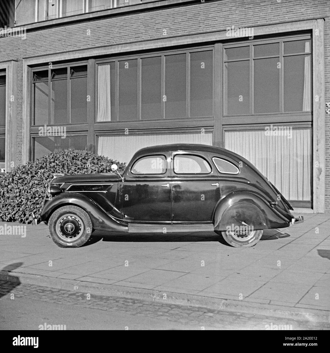 Ford V8 vor der Firmenzentrale der Ford Werke in Köln Niehl, Deutschland 1930er Jahre. Una Ford V8 nella parte anteriore del tedesco Ford sede a Colonia, Germania 1930s. Foto Stock