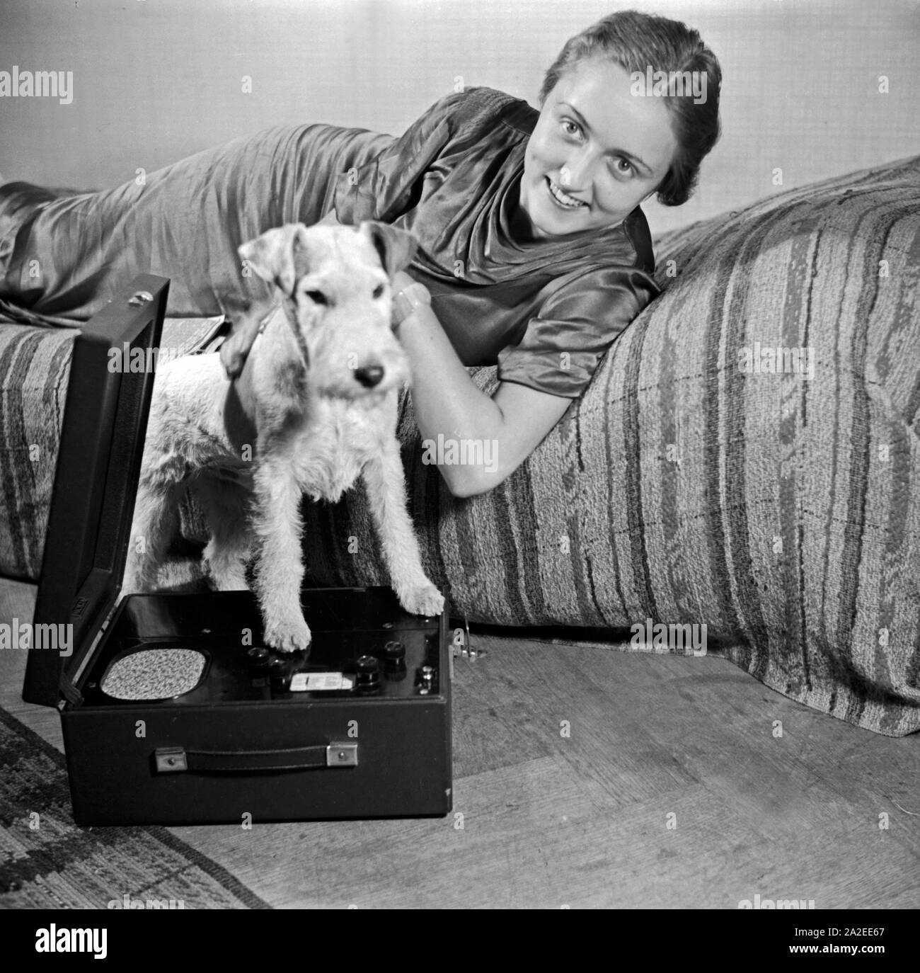 Eine Dame mit hund und Nora Olympia Kofferradio im Fotostudio in modalità zeitgenössischer, Deutschland 1930er Jahre. Una signora e il suo cane pet a photo studio in stile contemporaneo e alla moda, Germania 1930s. Foto Stock