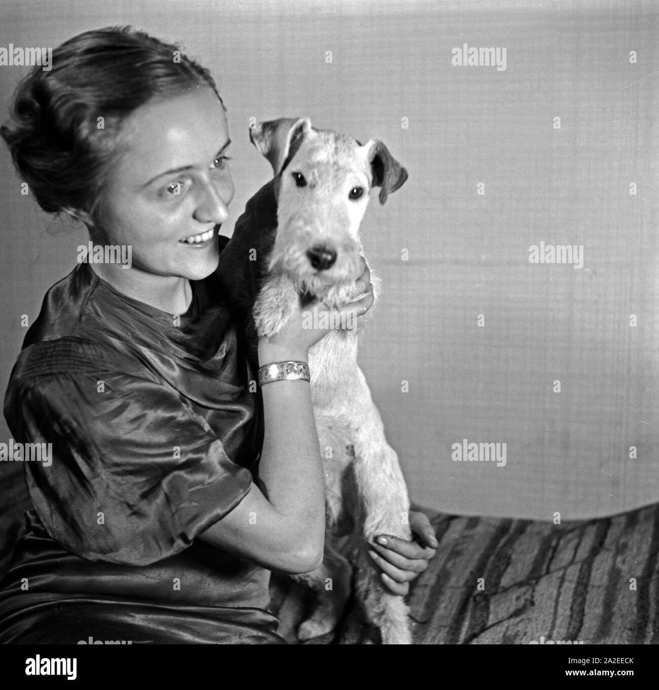 Eine Dame mit hund im Fotostudio in modalità zeitgenössischer, Deutschland 1930er Jahre. Una signora e il suo cane pet a photo studio in stile contemporaneo e alla moda, Germania 1930s. Foto Stock