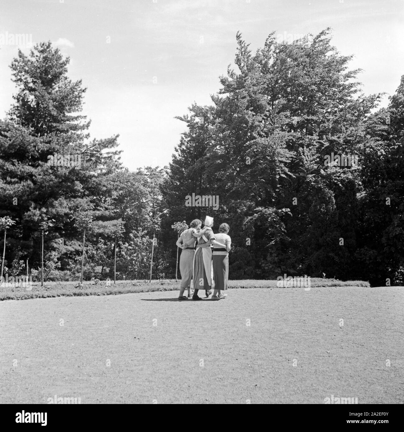 Zwei Frauen und eine Krankenschwester bei einem Erholungsspaziergang auf dem Gelände des Mutter und tipo Heimes in Tabarz, Thüringer Wald, 1930er Jahre. Due donne e un infermiere passeggiando per i giardini di una donna e di ricreazione del bambino a casa a Tabarz, Turingia, 1930s. Foto Stock