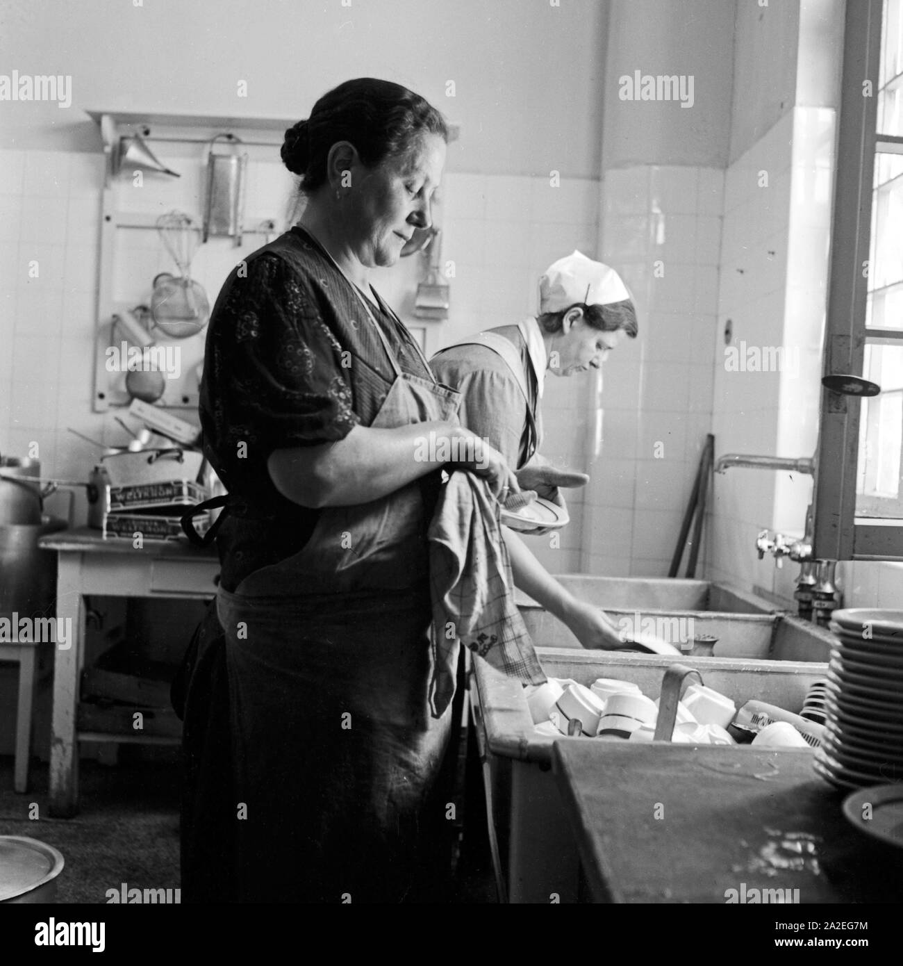 Frauen beim Spülen in der Küche des Mutter und tipo Heimes in Tabarz im Thüringer Wald. Le donne facendo il lavaggio fino nella cucina di una madre e un bambino ricreazione home a Tabarz, Turingia. Foto Stock