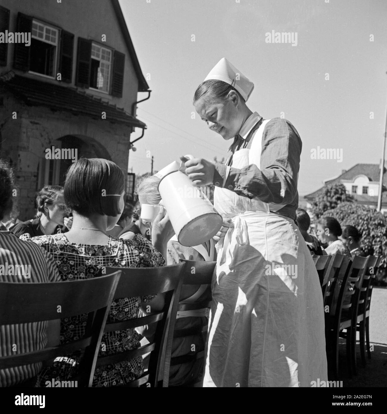 Eine Schwester teilt Kaffee aus un Frauen beim Frühstück im Mutter und tipo Heim in Tabarz im Thüringer Wald. Un infermiere versando il caffè per le donne di fare colazione in una madre e un bambino ricreazione home a Tabarz, Turingia. Foto Stock