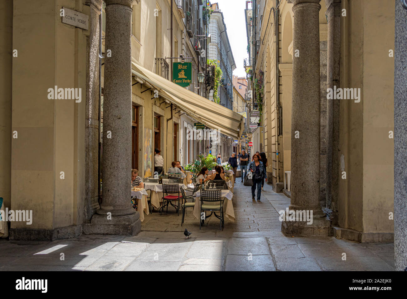 Persone di mangiare al di fuori di un ristorante lungo la Via Conte Verde,una strada stretta a Torino,Italia Foto Stock