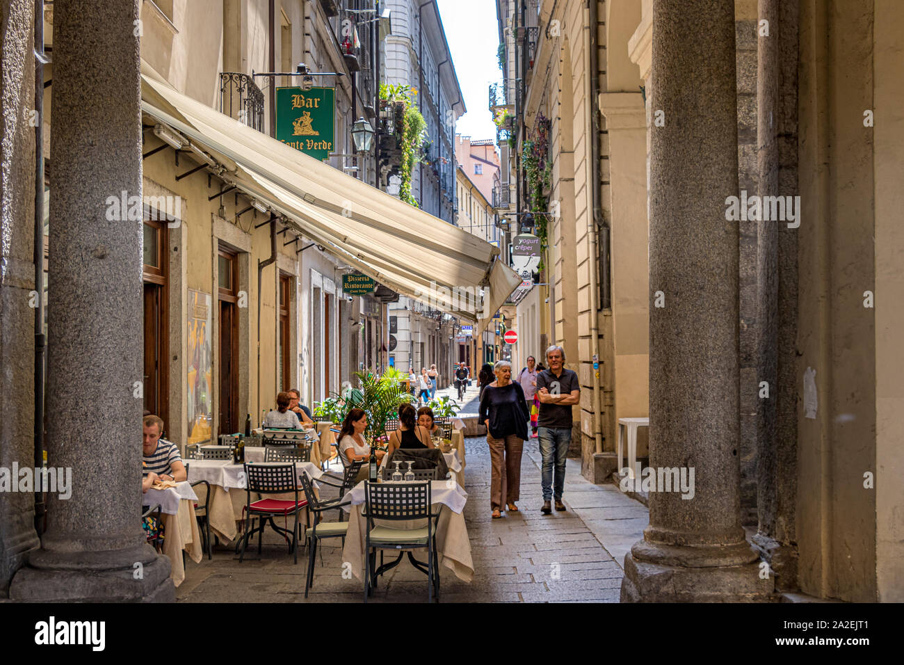 Persone di mangiare al di fuori di un ristorante lungo la Via Conte Verde,una strada stretta a Torino,Italia Foto Stock