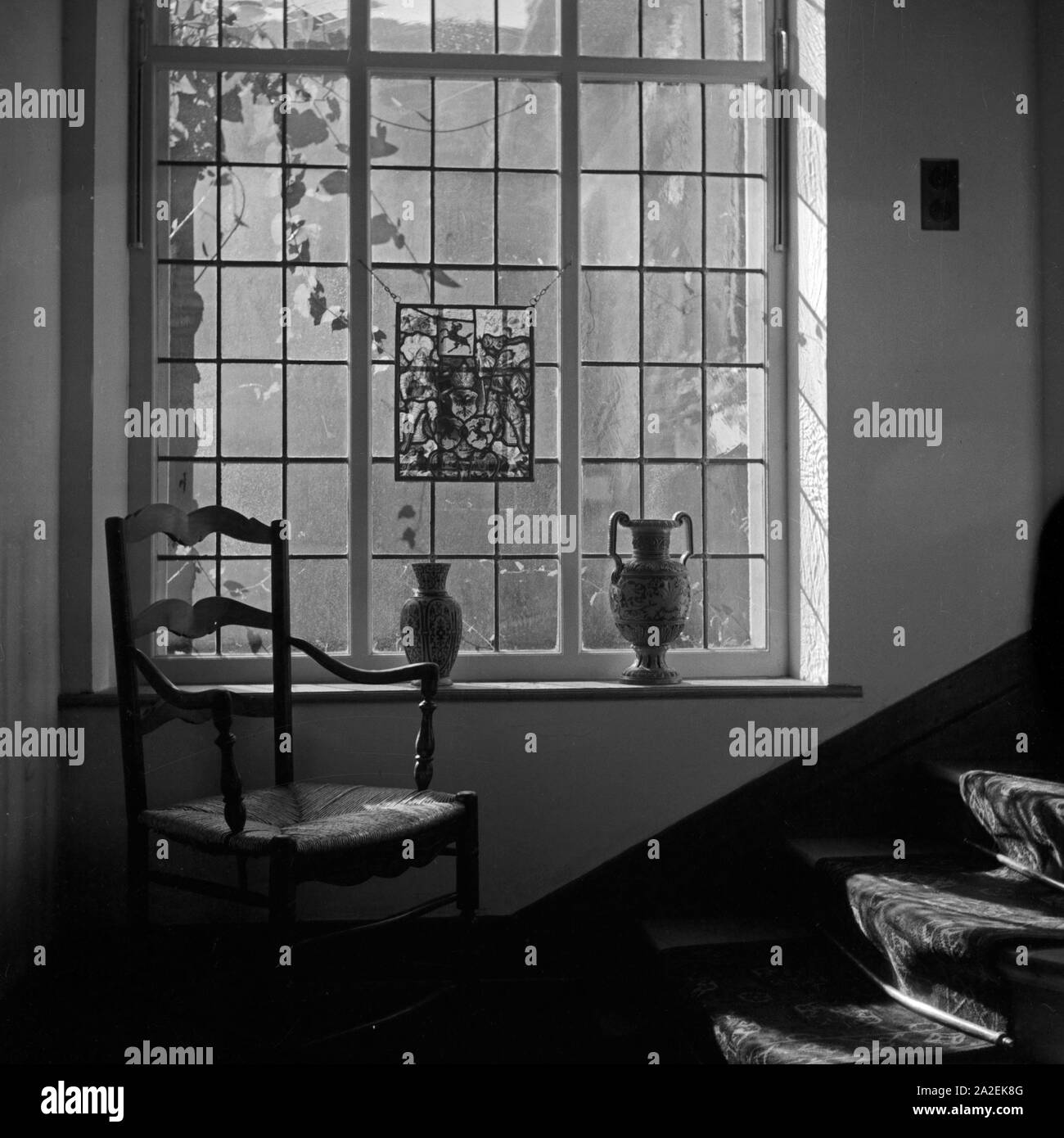 Blick in ein altes hölzernes Treppenhaus mit Butzenglasscheiben eines Hauses in Triberg im Schwarzwald, Deutschland 1930er Jahre. Vista in una vecchia scala di legno all'interno di una casa a Triberg nella Foresta Nera, Germania 1930s. Foto Stock