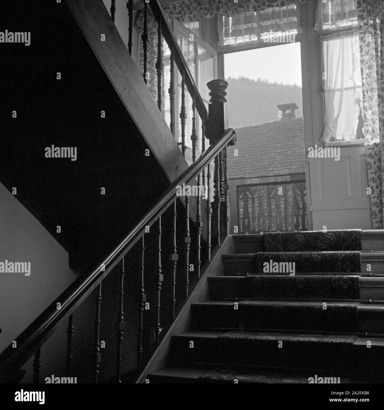 Blick in ein altes hölzernes Treppenhaus eines Hauses in Triberg im Schwarzwald, Deutschland 1930er Jahre. Vista in una vecchia scala di legno all'interno di una casa a Triberg nella Foresta Nera, Germania 1930s. Foto Stock
