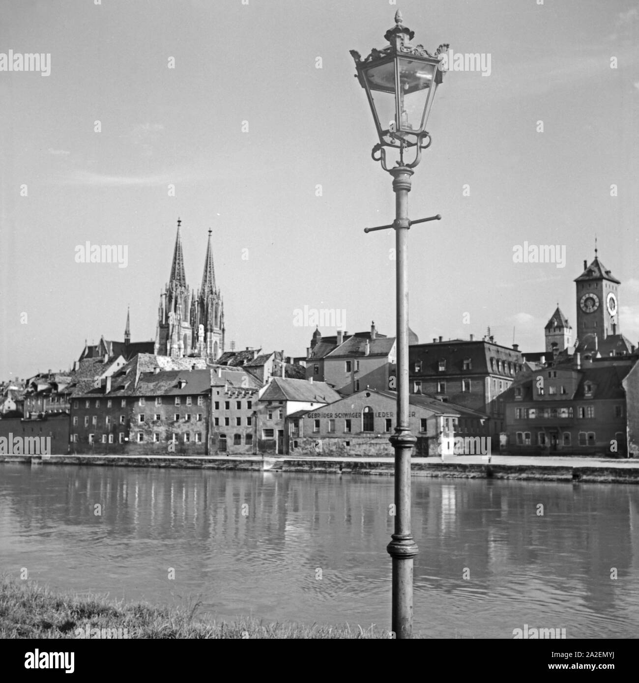 Blick auf das Panorama von Regensburg mit der Donau, dem Dom und Uhrturm dem am alten Rathaus, Deutschland 1930er Jahre. Regensburg skyline con cattedrale, fiume Daunbe e la torre dell'orologio del municipio della città vecchia, Germania 1930s. Foto Stock