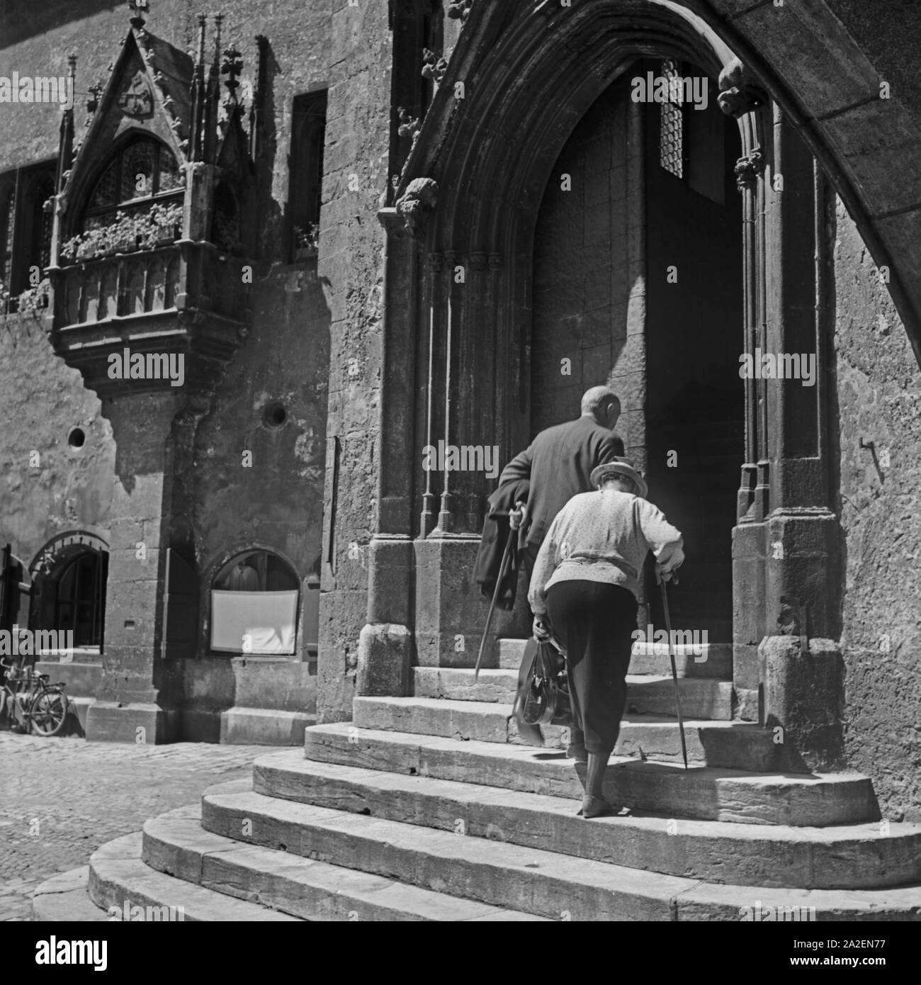 Altes Ehepaar auf dem Weg ins Rathaus in Regensburg, Deutschland 1930er Jahre. Una vecchia coppia sul loro modo al vecchio Regensburg town hall, Germania 1930s. Foto Stock