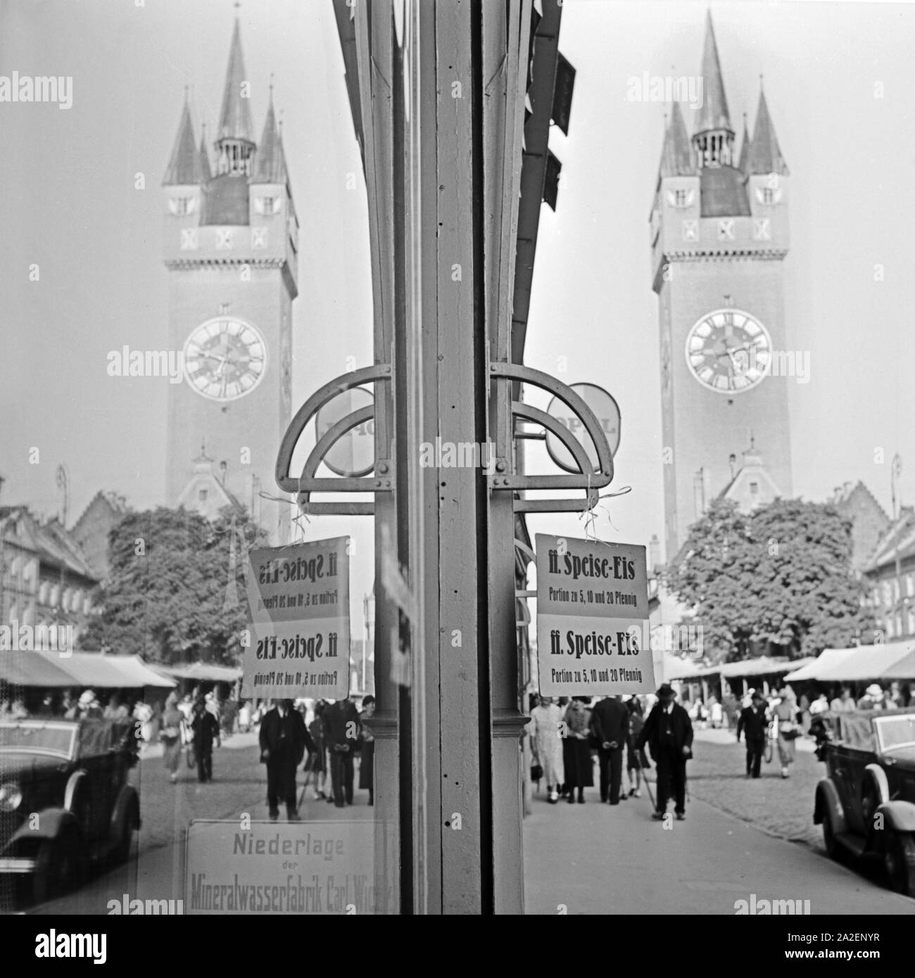 Der Stadturm von Straubing spiegelt sich in der Schaufensterscheibe eines Eisladens, Deutschland 1930er Jahre. Straubing city tower riflettendo in una vetrina di un'uscita per gelato, Germania 1930s. Foto Stock