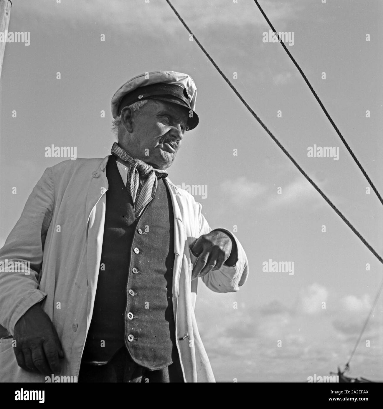 Kapitän eines Segelboots in der Ostsee bei Pillkoppen in Ostpreußen, Deutschland 1930er Jahre. Il capitano di una barca a vela sul Mar Baltico vicino Pillkoppen nella Prussia orientale, Germania 1930s. Foto Stock