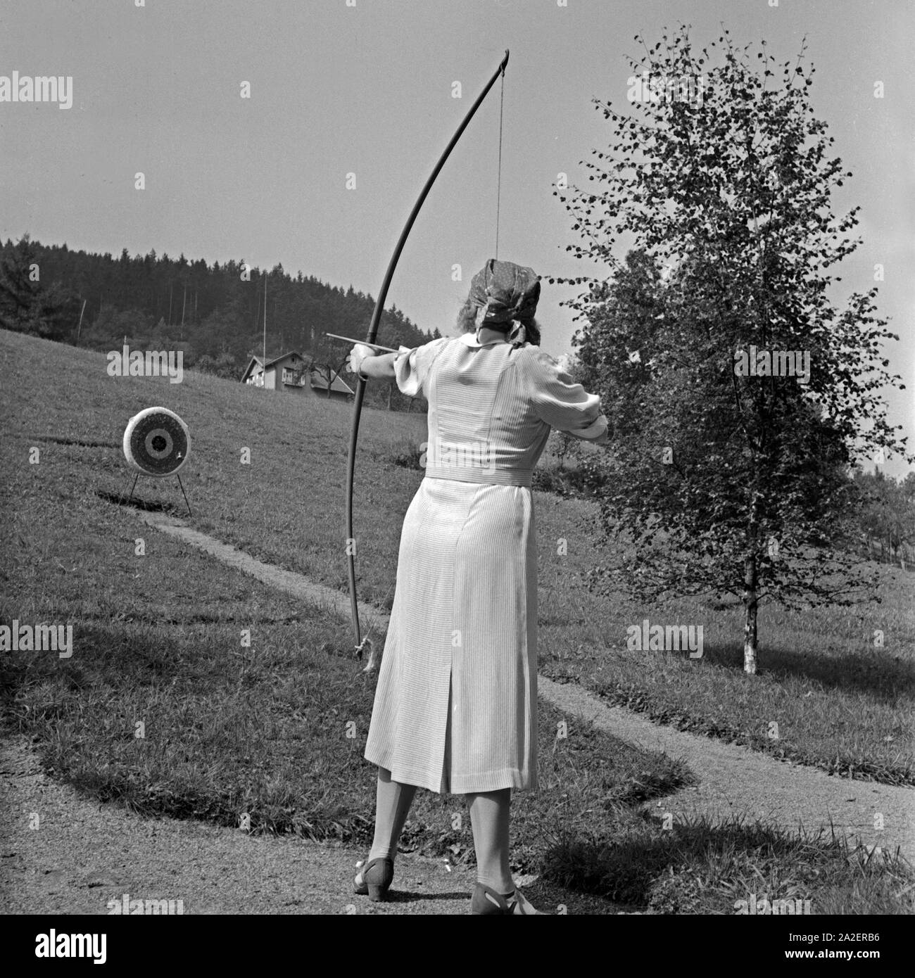Eine Frau übt sich im Bogenschießen, Deutschland 1930er Jahre. Una donna Foto Stock