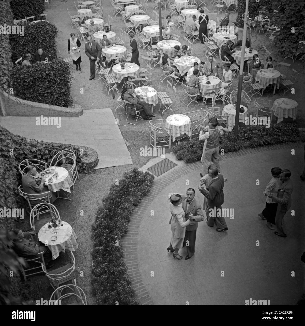 Tische einer Außengastronomie Tanzfläche mit in Wildbad im Schwarzwald, Deutschland 1930er Jahre. Le tabelle di un esterno di gastronomia e dancefloor a Wildbad nella Foresta Nera, Germania 1930s. Foto Stock