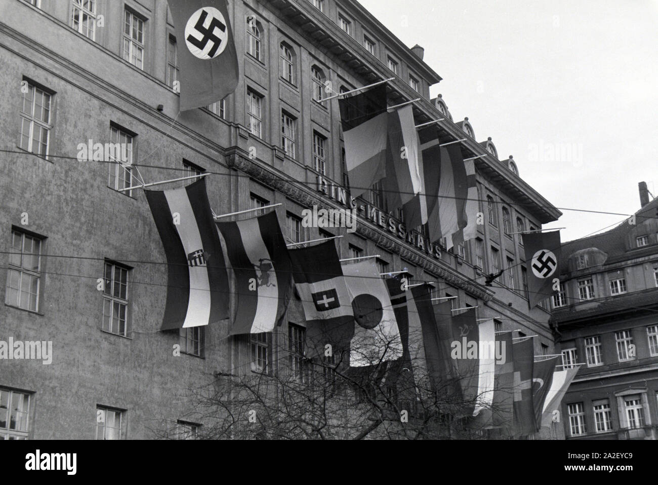 Außenansicht auf das Ring-Messehaus mit Fahnen der teilnehmenden Nationen " an der Leipziger Frühjahrsmesse, Deutschland 1941. Vista esterna del Ring-Messehaus con le bandiere delle nazioni partecipanti della Leipziger Frühjahrsmesse, Germania 1941. Foto Stock